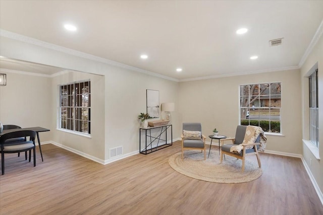 sitting room with ornamental molding and light hardwood / wood-style floors