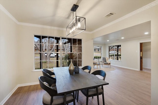 dining room featuring crown molding, a notable chandelier, and hardwood / wood-style flooring