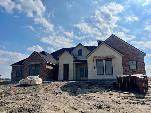 property under construction with stone siding and brick siding