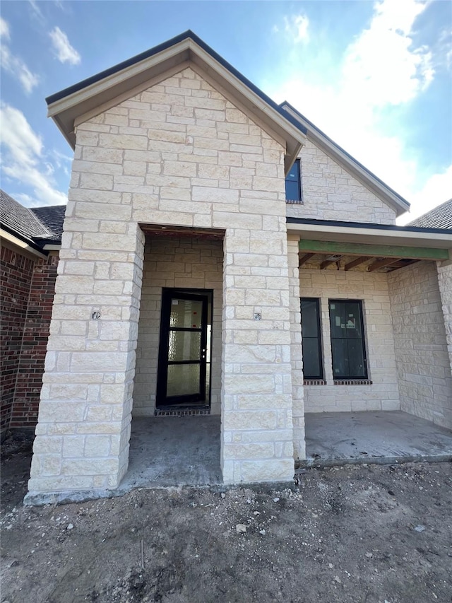 doorway to property featuring stone siding