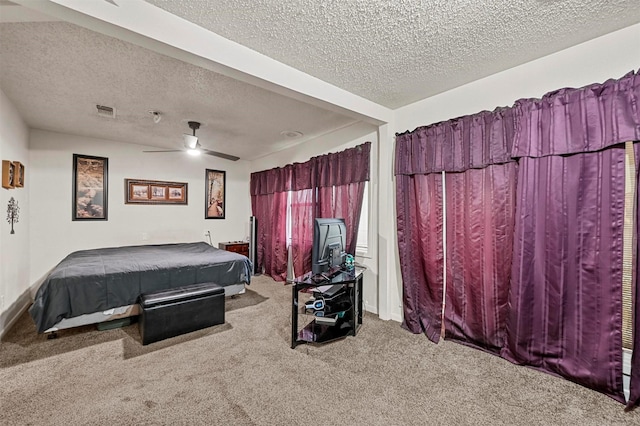 carpeted bedroom featuring ceiling fan and a textured ceiling