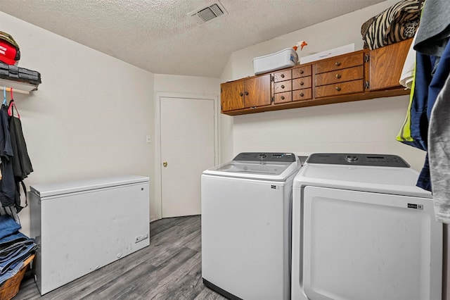 laundry room with cabinets, washer and clothes dryer, hardwood / wood-style floors, and a textured ceiling