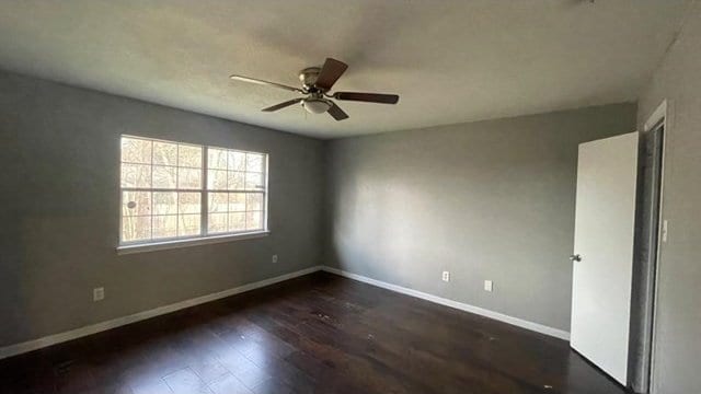 empty room with ceiling fan and dark hardwood / wood-style floors