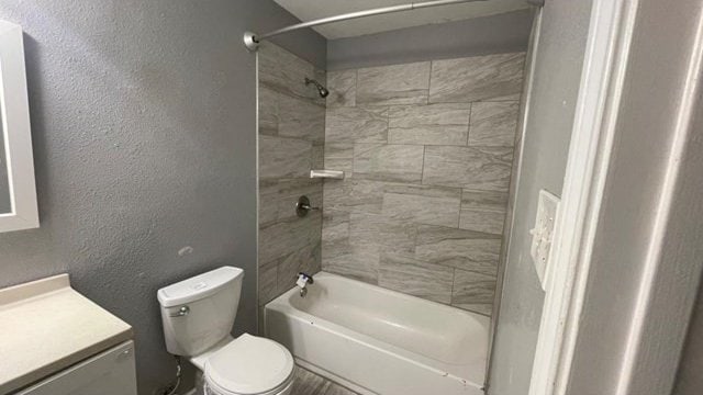 full bathroom with tiled shower / bath combo, vanity, and toilet