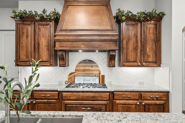 kitchen featuring stainless steel gas stovetop and light stone countertops