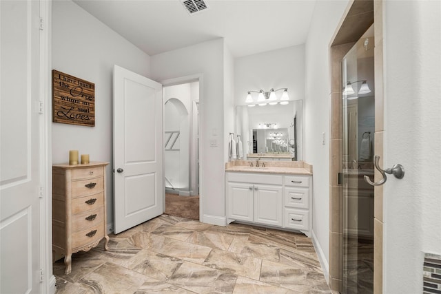 bathroom with vanity and a shower with door