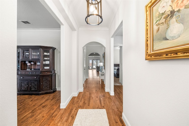 hallway with hardwood / wood-style flooring and ornamental molding