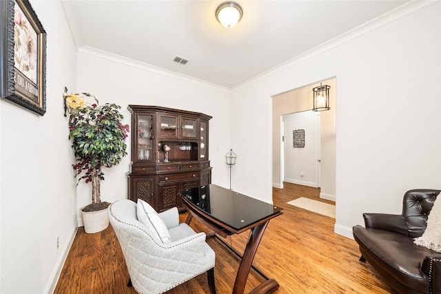 office area with crown molding and light hardwood / wood-style floors