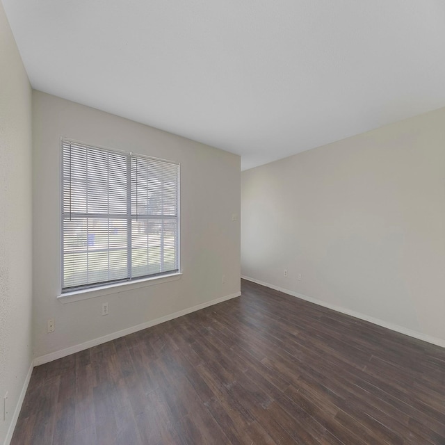 spare room with dark wood-type flooring