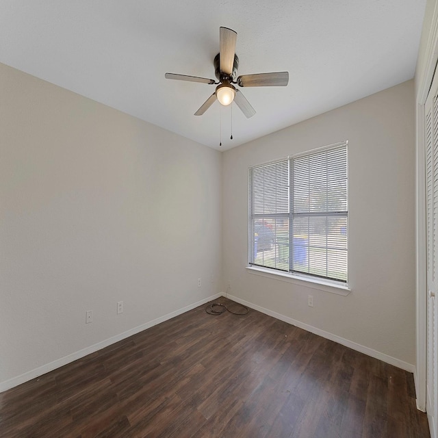 spare room with dark hardwood / wood-style flooring and ceiling fan