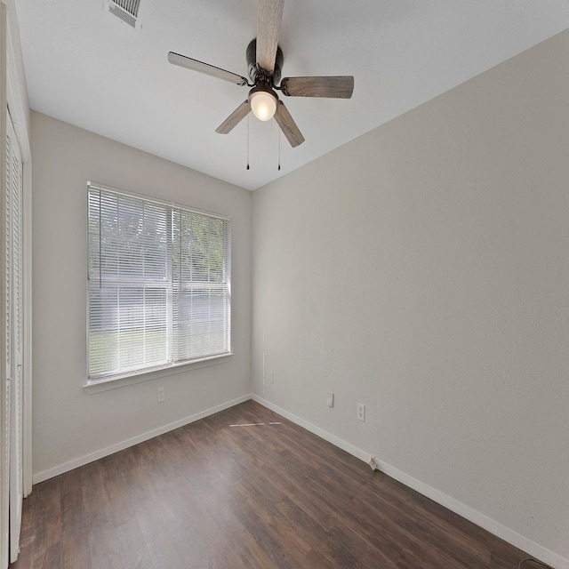 spare room featuring dark wood-type flooring and ceiling fan