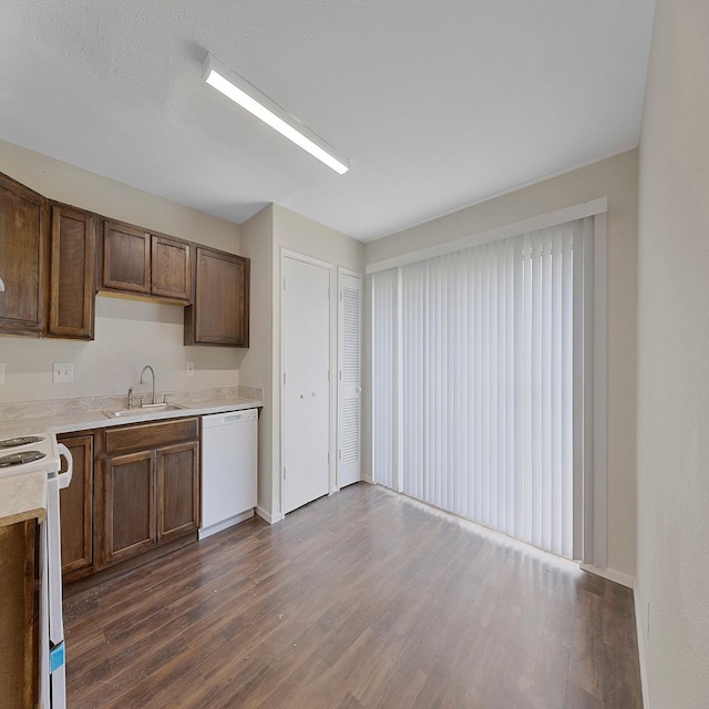 kitchen with sink, dark wood-type flooring, a textured ceiling, and white appliances