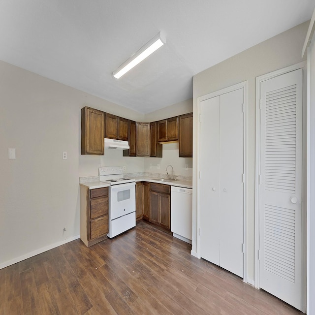 kitchen with dark wood-type flooring, sink, and white appliances