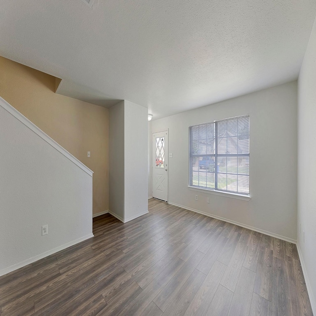 interior space with dark wood-type flooring and a textured ceiling