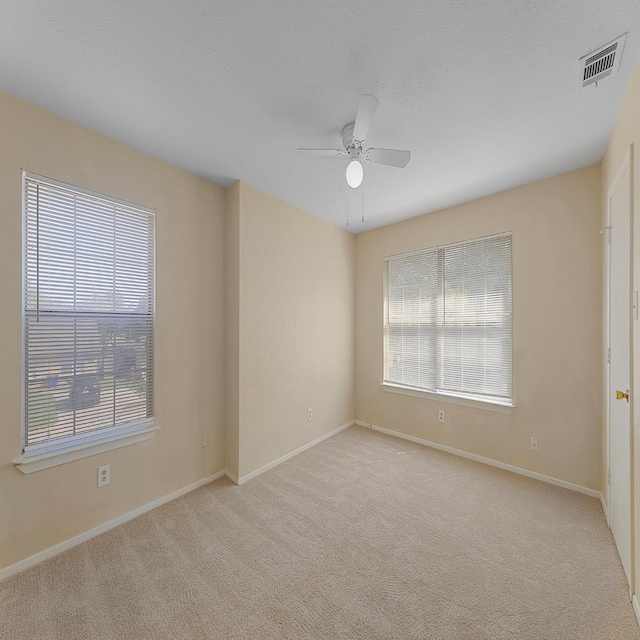 empty room featuring light carpet and ceiling fan