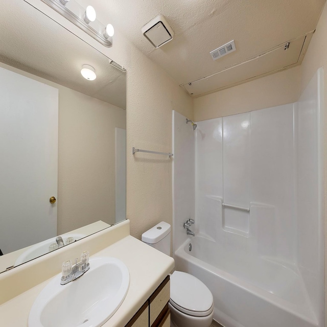 full bathroom featuring bathing tub / shower combination, vanity, a textured ceiling, and toilet