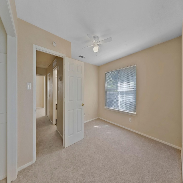 carpeted spare room with ceiling fan