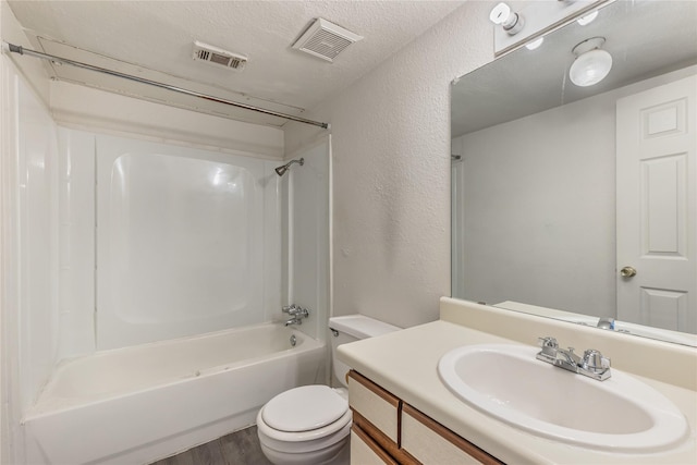 full bathroom featuring wood-type flooring, vanity, toilet, bathing tub / shower combination, and a textured ceiling