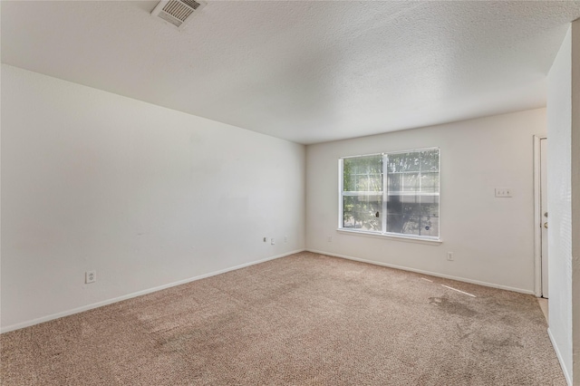 unfurnished room with light carpet and a textured ceiling