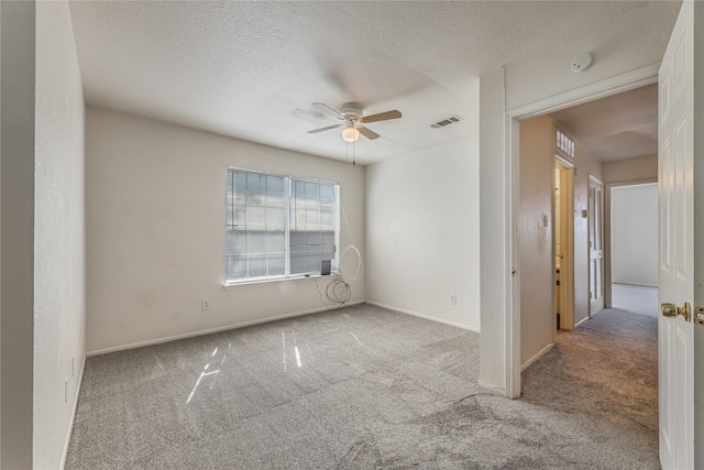 carpeted spare room with ceiling fan and a textured ceiling