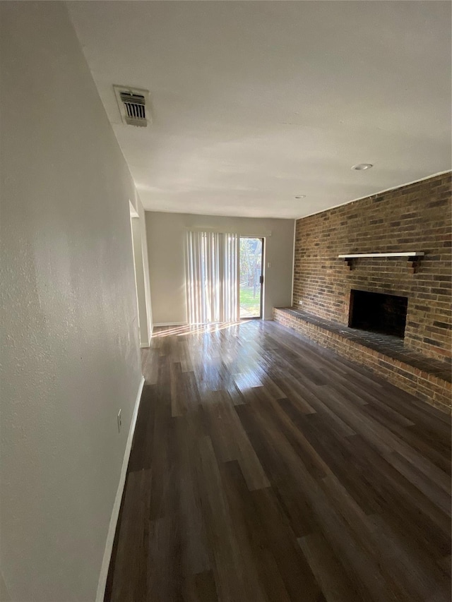 unfurnished living room featuring a fireplace and dark hardwood / wood-style floors