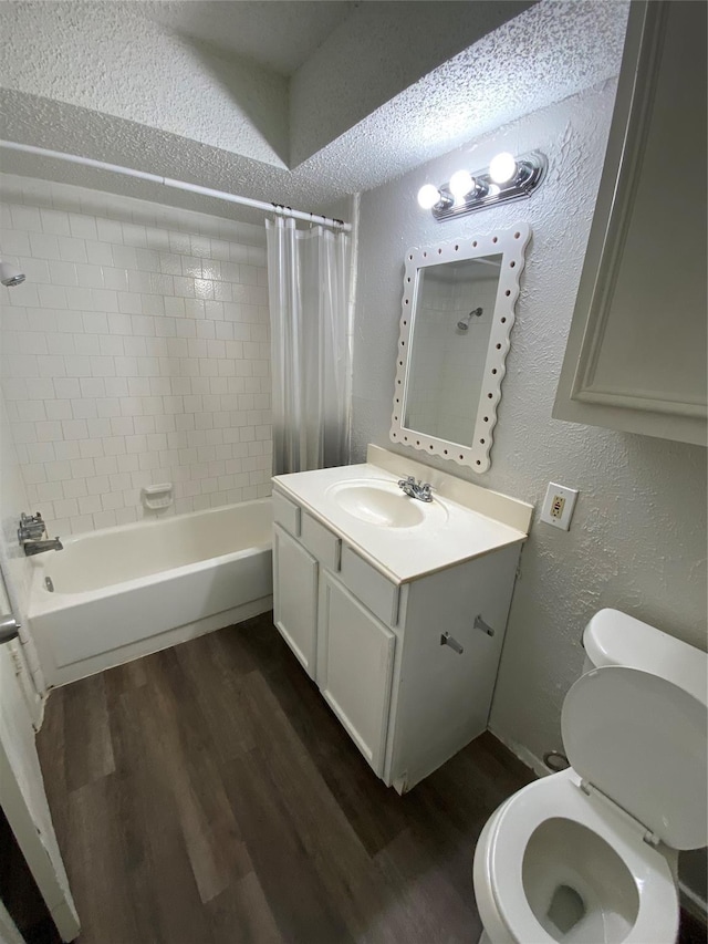 full bathroom featuring shower / tub combo with curtain, vanity, wood-type flooring, a textured ceiling, and toilet