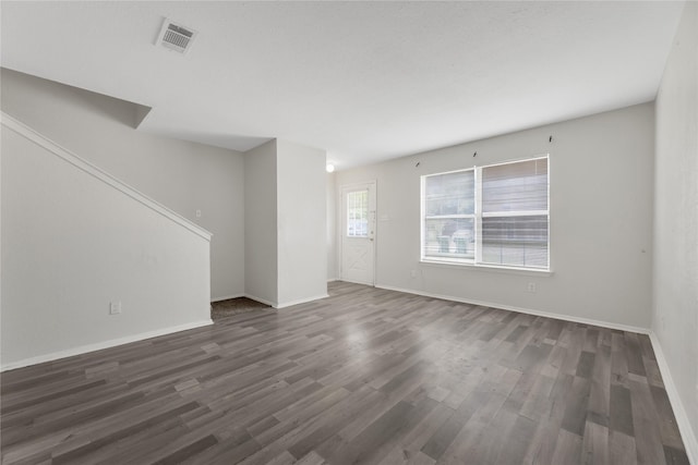 unfurnished living room with dark wood-type flooring