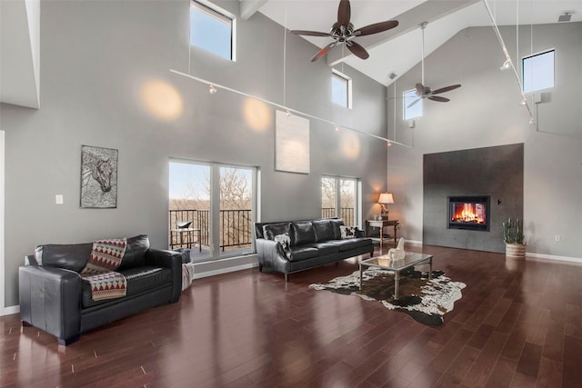 living room featuring ceiling fan, dark hardwood / wood-style floors, and a high ceiling