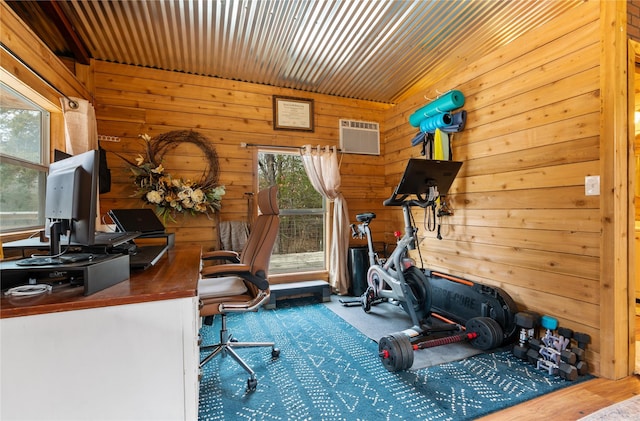 exercise room featuring a wall mounted air conditioner, vaulted ceiling, and wood walls