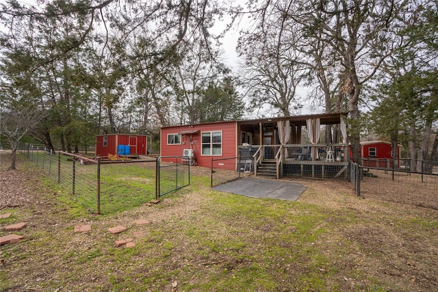 rear view of property with a yard and a storage unit