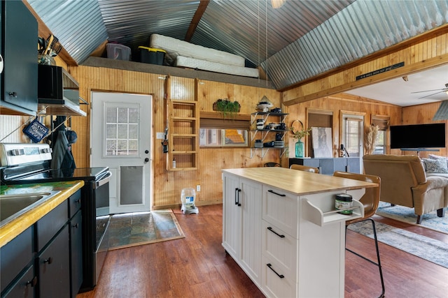 kitchen with lofted ceiling, white cabinets, a kitchen bar, stainless steel range with electric stovetop, and dark wood-type flooring