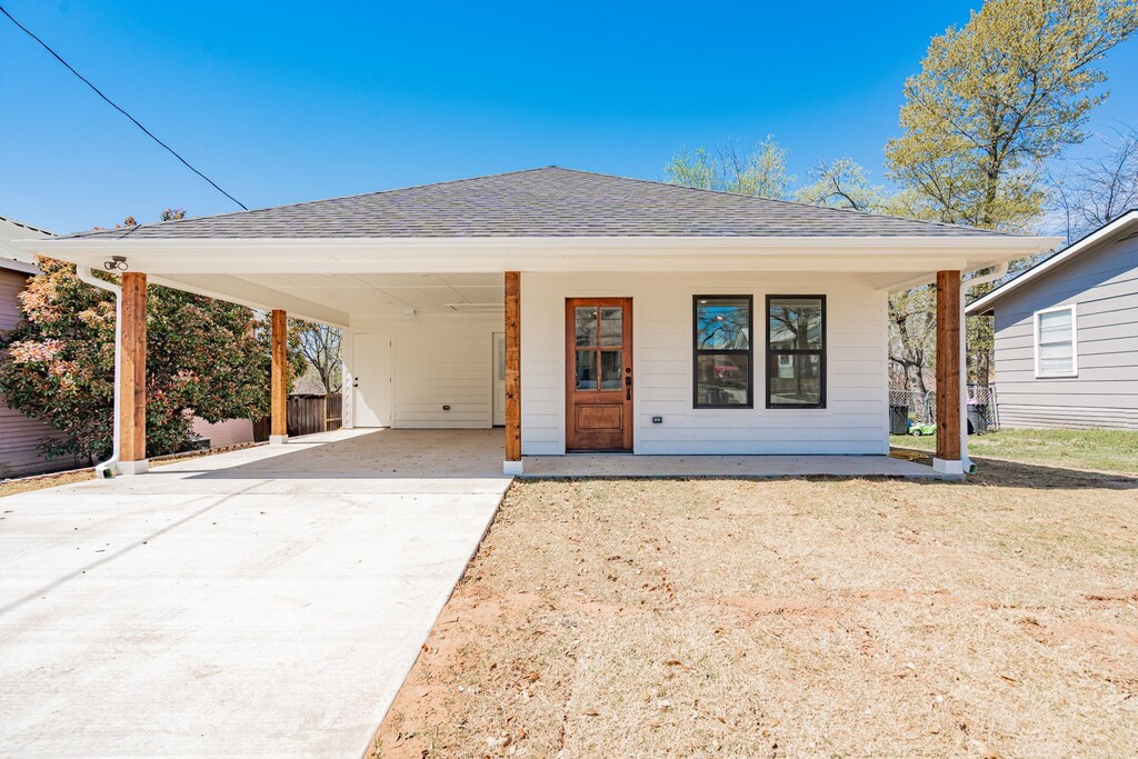 exterior space with driveway and roof with shingles