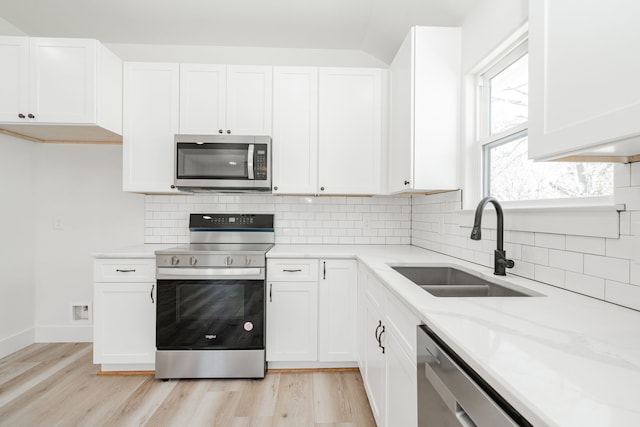 308 Santa Fe, Wolfe City, TX 75496 - kitchen with a sink, light stone countertops, stainless steel appliances, light wood-style floors, and decorative backsplash