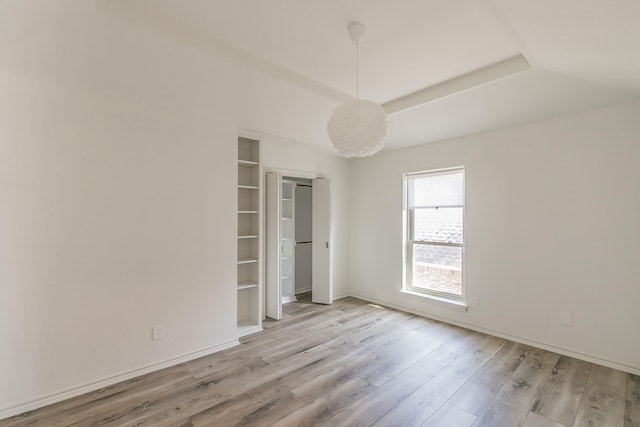 unfurnished bedroom featuring lofted ceiling and light hardwood / wood-style floors