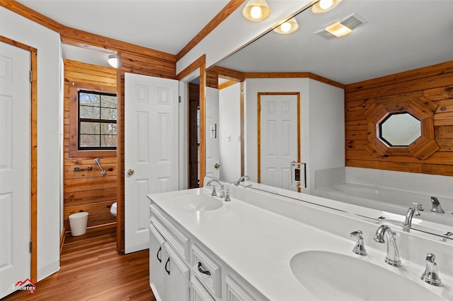 bathroom with vanity, a tub, hardwood / wood-style floors, and wooden walls