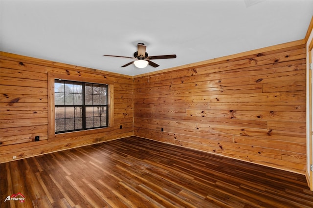 empty room featuring ceiling fan, wooden walls, and dark hardwood / wood-style flooring