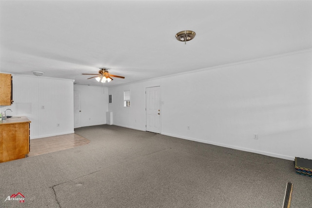 unfurnished living room with ornamental molding, sink, and ceiling fan