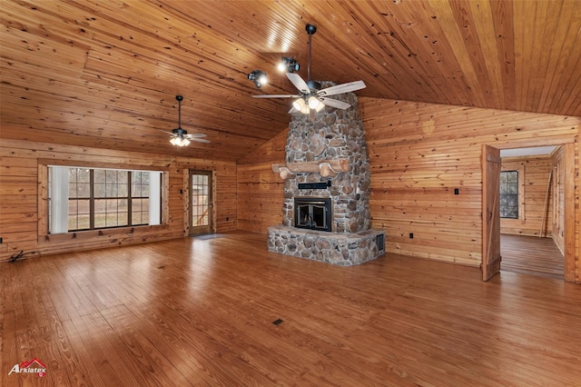 unfurnished living room featuring hardwood / wood-style floors, a stone fireplace, vaulted ceiling, and wooden ceiling