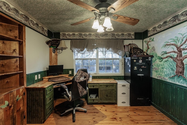 home office with ceiling fan, light hardwood / wood-style floors, and wood walls