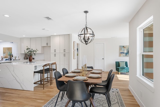 dining room with baseboards, an inviting chandelier, recessed lighting, light wood-style floors, and visible vents