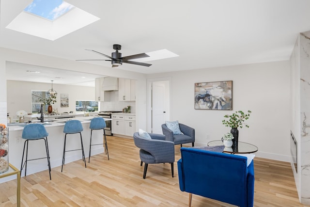 interior space featuring a breakfast bar area, premium range hood, white cabinets, stainless steel range with gas cooktop, and kitchen peninsula