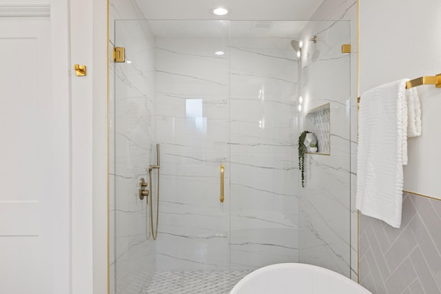 bathroom featuring tile walls and a shower with shower door