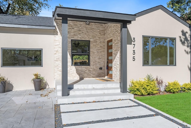 property entrance with stone siding and stucco siding