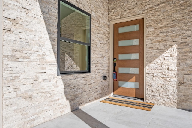 view of exterior entry featuring stone siding