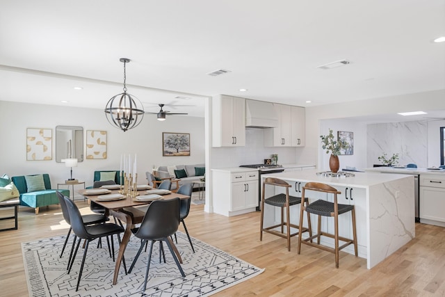 dining area featuring visible vents, light wood-style flooring, recessed lighting, and a chandelier
