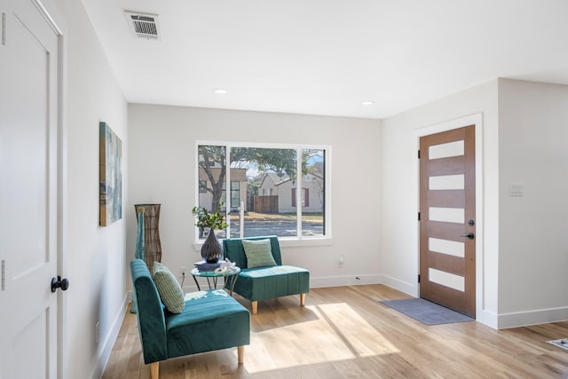 foyer entrance with light wood-style floors, baseboards, and visible vents