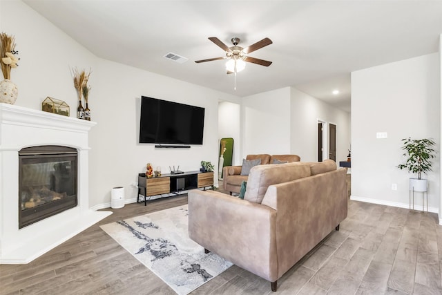 living room with ceiling fan and light wood-type flooring