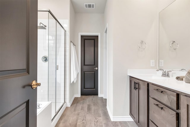 bathroom with wood-type flooring, an enclosed shower, and vanity