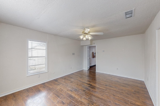 empty room featuring ceiling fan, a textured ceiling, and dark hardwood / wood-style flooring