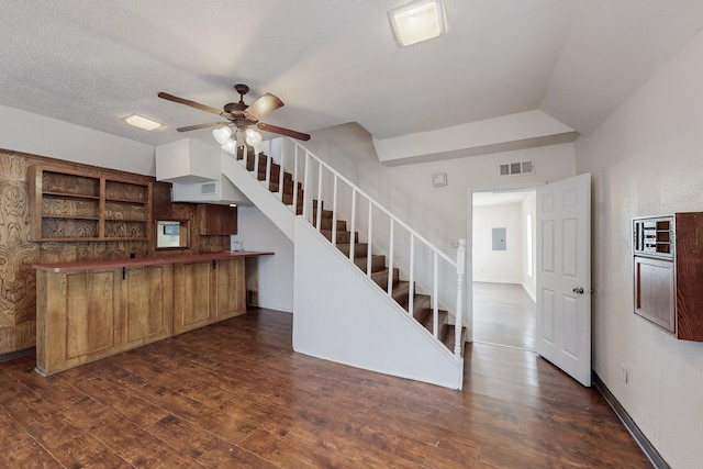 kitchen with a textured ceiling, dark hardwood / wood-style flooring, electric panel, kitchen peninsula, and ceiling fan